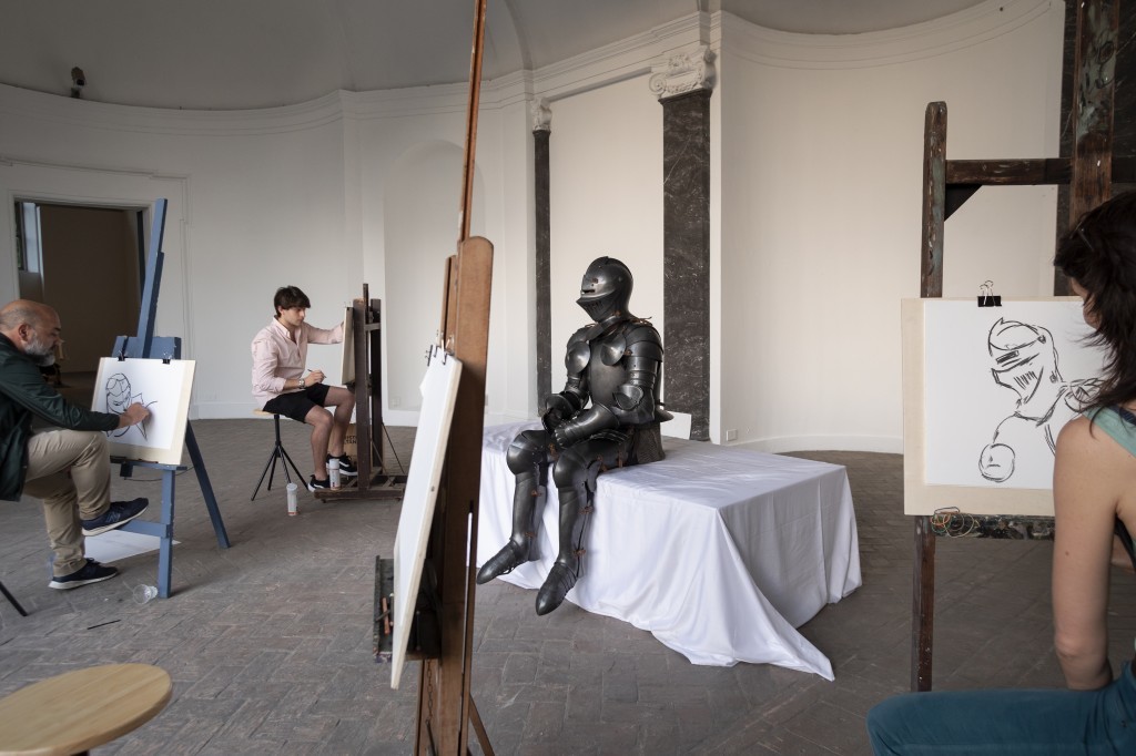Self-portrait in armour (Take me I’m yours), 2018, Wood, cotton fabric, painting easels with stools, armour, drawing material, live model, Dimension vary with installation, Courtesy of the artist, ChertLüdde, Berlin and T293, Rome