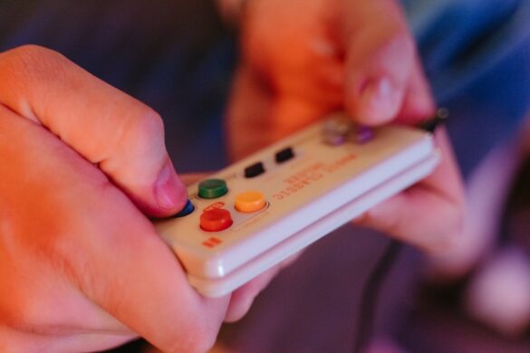 person holding a vintage game console controller